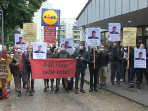 20 Menschen vor Lidl in Berlin mit Protestplakaten 