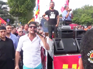 Demonstration, among the people a man with a microphone beside the vehicle with the loudspeakers